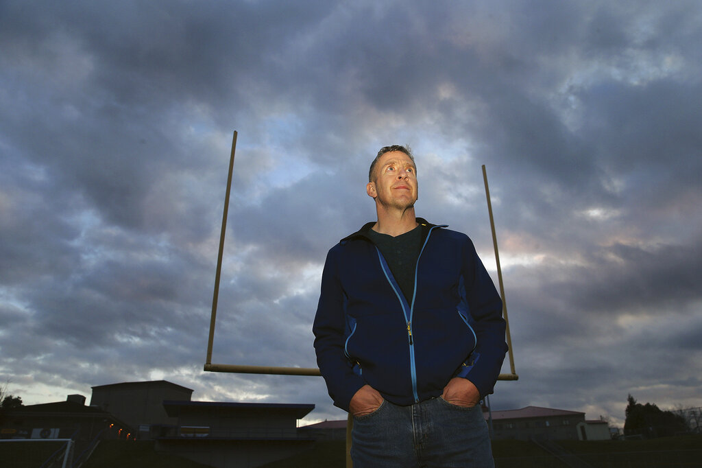 FILE - Former Bremerton High School assistant football coach Joe Kennedy stands on the field at Bremerton Memorial Stadium, Nov. 5, 2015. After the June 27, 2022 U.S. Supreme Court ruling in favor of the high school football coach’s right to pray on the field after games, there were predictions of sweeping consequences from across the ideological spectrum. But three months after the decision, there’s no sign that large numbers of coaches are following Kennedy’s high-profile example.