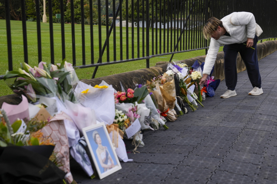 A man lays flowers at a floral tribute outside Government House following the passing of Queen Elizabeth II in Sydney, Australia, Friday, Sept. 9, 2022. Queen Elizabeth II, Britain's longest-reigning monarch and a rock of stability in a turbulent era for her country and the world, died Thursday, Sept. 8 after 70 years on the throne. She was 96.