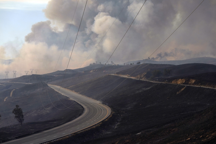 Smoke from the Route Fire drifts over the closed-off Interstate 5 on Wednesday in Castaic, Calif.