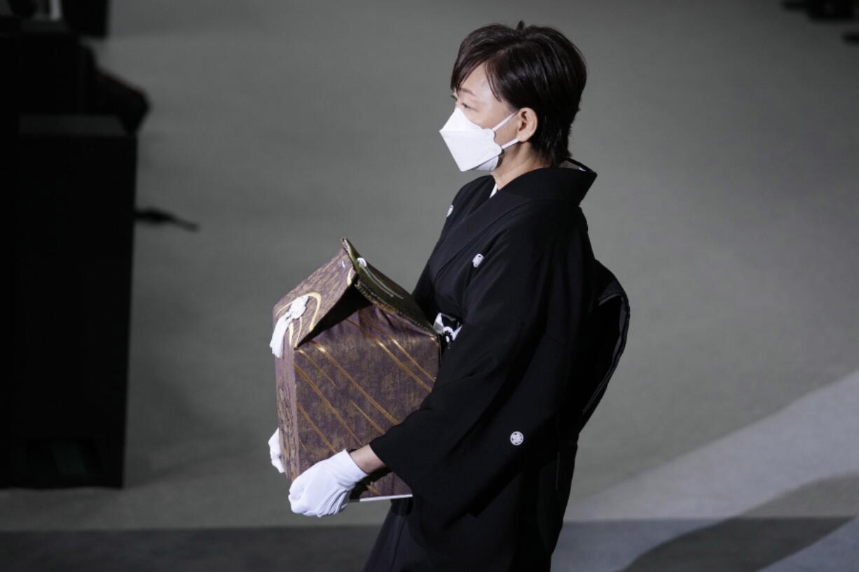Akie Abe, wife of former Prime Minister Shinzo Abe, carries a cinerary urn containing his ashes at his state funeral, Tuesday, Sept. 27, 2022, in Tokyo. Abe was assassinated in July.