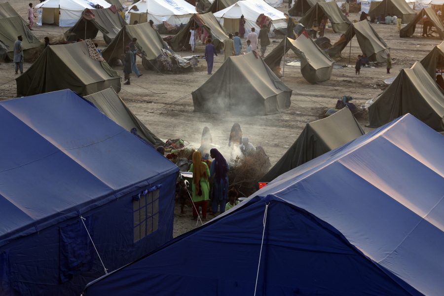 Victims of heavy flooding from monsoon rains take refuge as they prepare tea at a temporary tent housing camp organized by the UN Refugee Agency (UNHCR), in Sukkur, Pakistan, Saturday, Sept. 10, 2022. Months of heavy monsoon rains and flooding have killed over a 1000 people and affected 3.3 million in this South Asian nation while half a million people have become homeless.