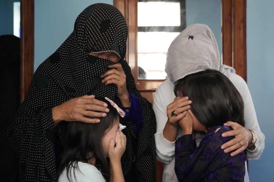 The family of a 19-years old girl who was victim of a suicide bomber mourns, in Kabul, Afghanistan, Friday, Sept. 30, 2022. A Taliban spokesman says a suicide bomber has killed several people and wounded others at an education center in a Shiite area of the Afghan capital. The bomber hit while hundreds of teenage students inside were taking practice entrance exams for university, a witness says.