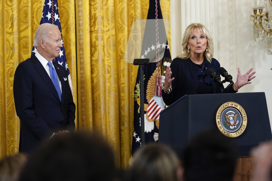 President Joe Biden listens as first lady Jill Biden speaks during a reception in the East Room of the White House for Hispanic Heritage Month in Washington, Friday, Sept. 30, 2022.