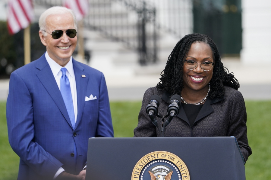 FILE - President Joe Biden listens as Judge Ketanji Brown Jackson speaks during an event on the South Lawn of the White House in Washington, April 8, 2022, celebrating the confirmation of Jackson as the first Black woman to reach the Supreme Court. On Friday, Sept. 30, 2022, Biden, Vice President Kamala Harris and their spouses will attend the ceremonial investiture for Justice Brown Jackson, the Supreme Court's newest member according to a White House official.