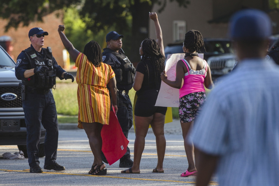 Brittany Martin, second from left, wearing striped clothing, confronts police before demonstrators in support of George Floyd march with an escort around downtown Sumter, S.C., on May 31, 2020. Martin, a pregnant Black activist serving four years in prison for her behavior at racial justice protests, is scheduled to have her sentence reconsidered as she struggles to reach her due date behind bars.