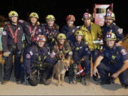 This image provided by the Pasadena Fire Department showing firefighters pose with a Cesar a blind dog that was rescued from a hold in Pasadena, Calif. on Tuesday, Sept. 20, 2022. Firefighters have rescued a 13-year-old blind dog that fell into a hole at a California construction site. The dog, named Cesar, lives next to the site in Pasadena with his owner. He apparently wandered onto the site, said Cesar's owner Mary, who declined to give her last name.