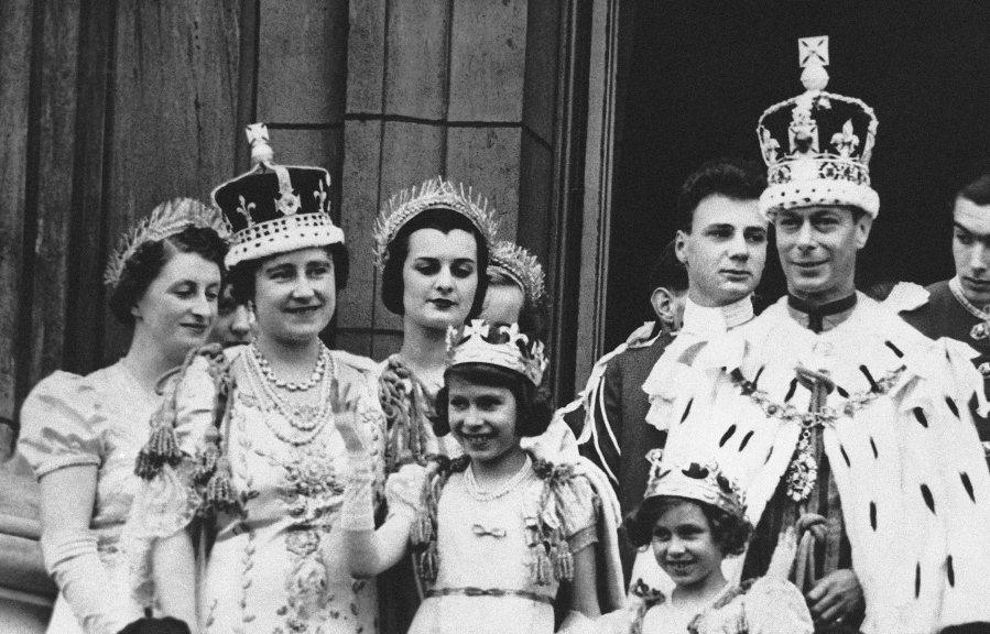 FILE - Princess Elizabeth, centre, age 11, appears on the balcony of Buckingham Palace after the coronation of her father, King George VI, right, in London, May 12, 1937. Queen Elizabeth II, Britain's longest-reigning monarch and a rock of stability across much of a turbulent century, has died. She was 96. Buckingham Palace made the announcement in a statement on Thursday Sept. 8, 2022.