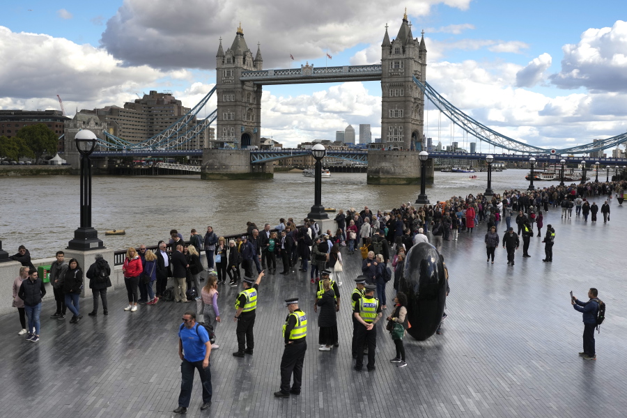 People walk in a queue in front of Tower Bridge to pay their respects to the late Queen Elizabeth II during the Lying-in State at Westminster Hall, in London, England, Friday, Sept. 16, 2022. The Queen will lie in state in Westminster Hall for four full days before her funeral on Monday Sept. 19.