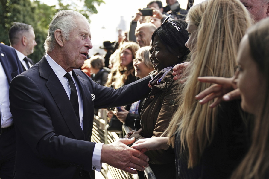 Britain's King Charles III meets members of the public in the queue along the South Bank, near to Lambeth Bridge as they wait to view Queen Elizabeth II lying in state ahead of her funeral on Monday, in London, Saturday, Sept. 17, 2022.
