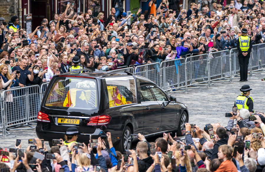 The hearse carrying the coffin of Queen Elizabeth II, draped with the Royal Standard of Scotland, passes the City Chambers on the Royal Mile, Edinburgh, Sunday, Sept. 11, 2022 on the journey from Balmoral to the Palace of Holyroodhouse in Edinburgh, where it will lie in rest for a day.