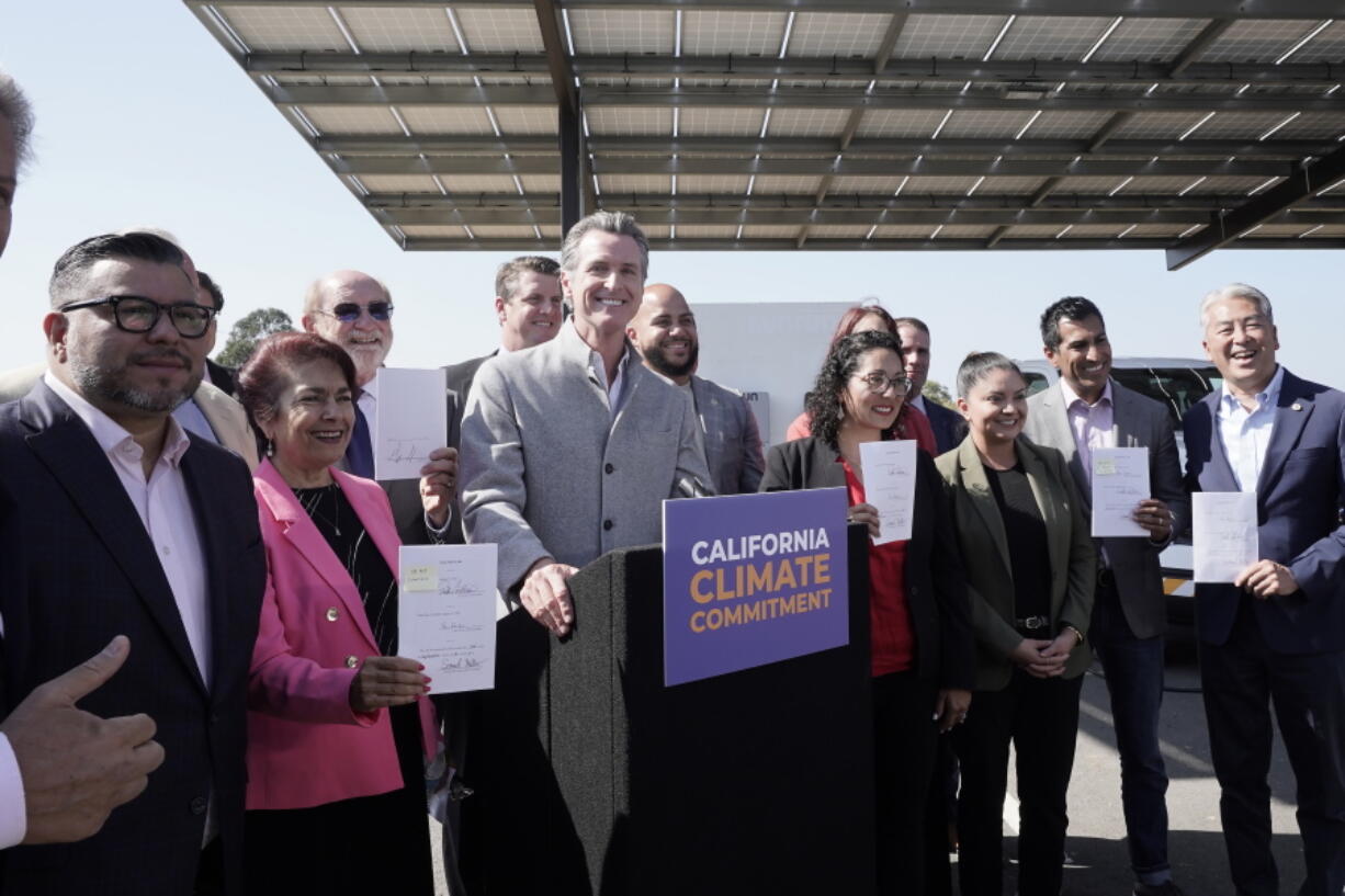 Gov. Gavin Newsom, center, poses with lawmakers after signing a package of legislation that accelerates the climate goals of the nation's most populous state at Mare Island in Vallejo, Calif., Friday, Sept. 16, 2022.