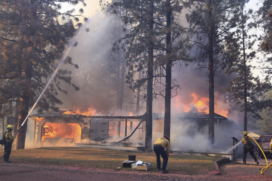 California Department of Forestry and Fire Protection firefighters try to stop flames from the Mill Fire from spreading on a property in the Lake Shastina subdivision northwest of Weed, Calif., Friday, Sept. 2, 2022. (Hung T.