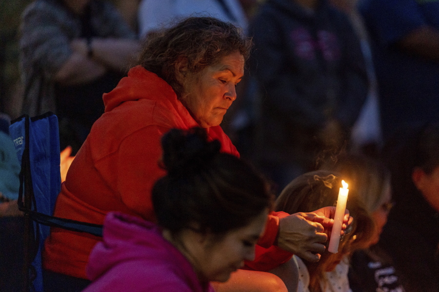 A mourner holds a candle at a vigil in honor of the victims of a mass stabbing incident at James Smith Cree Nation and Weldon, Saskatchewan, in front of City Hall in Prince Albert, Saskatchewan, on Wednesday, Sept. 7, 2022.