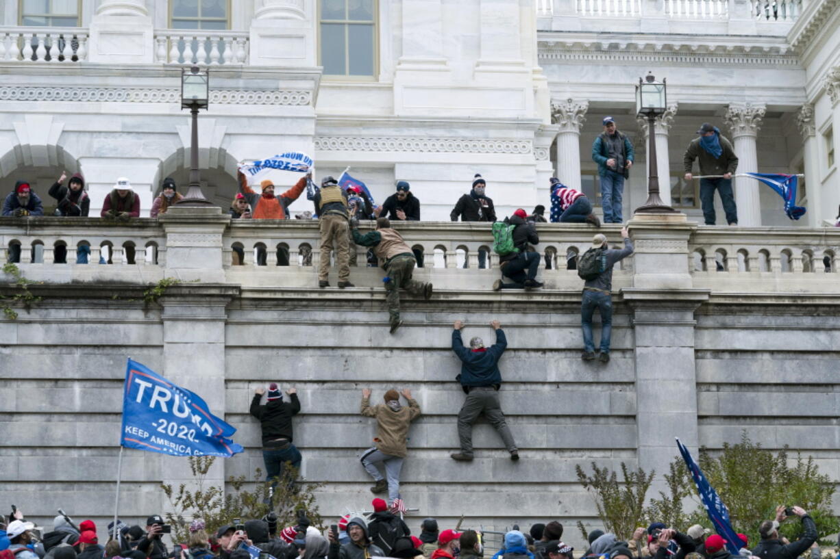 FILE - Violent insurrectionists loyal to President Donald Trump scale the west wall of the U.S. Capitol in Washington, Jan. 6, 2021. Anthony Robert Williams, of Michigan, was sentenced on Friday, Sept. 16, 2022, to five years in federal prison for his role in the U.S. Capitol attack by a mob that disrupted Congress from certifying President Joe Biden's 2020 electoral victory.