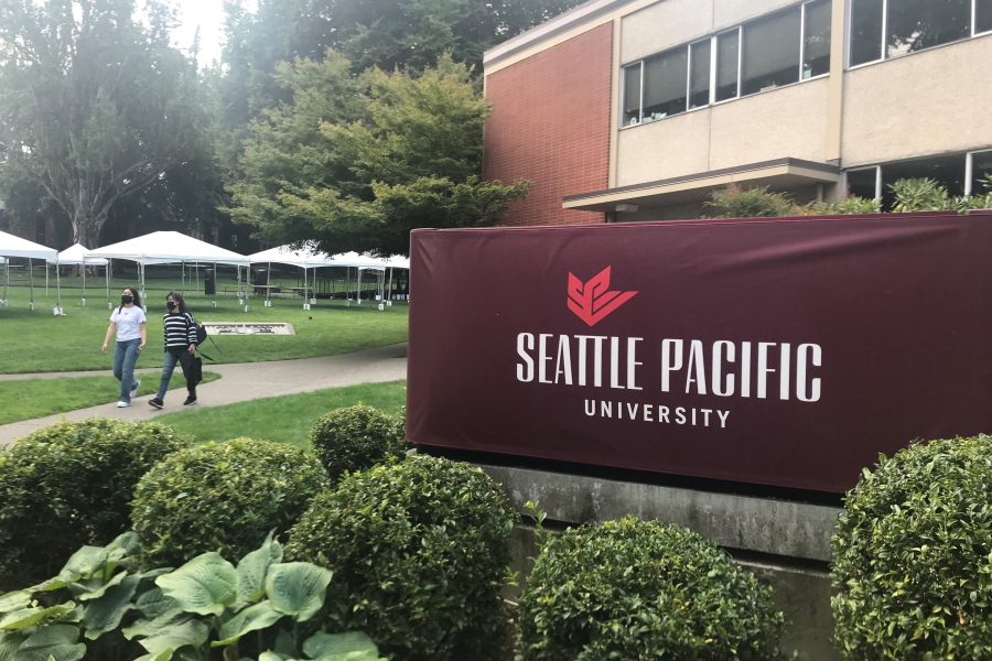 Students walk on the campus of Seattle Pacific University in Seattle on Sunday, Sept. 11, 2022. A group of students, faculty and staff at the Christian university have sued leaders of the board of trustees for refusing to scrap an employment policy barring people in same-sex relationships from full-time jobs at SPU.