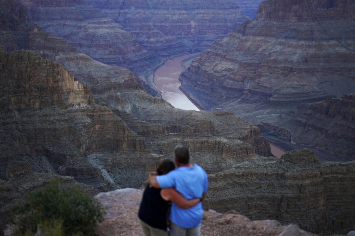 Alyssa Chubbuck, left, and Dan Bennett embrace while watching the sunset at Guano Point overlooking the Colorado River on the Hualapai reservation Monday, Aug. 15, 2022, in northwestern Arizona. In November 1922, seven land-owning white men brokered a deal to allocate water from the Colorado River, which winds through the West and ends in Mexico. During the past two decades, pressure has intensified on the river as the driest 22-year stretch in the past 1,200 years has gripped the southwestern U.S.