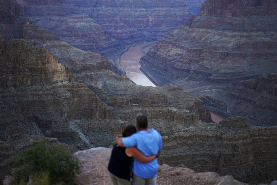 Alyssa Chubbuck, left, and Dan Bennett embrace while watching the sunset at Guano Point overlooking the Colorado River on the Hualapai reservation Monday, Aug. 15, 2022, in northwestern Arizona. In November 1922, seven land-owning white men brokered a deal to allocate water from the Colorado River, which winds through the West and ends in Mexico. During the past two decades, pressure has intensified on the river as the driest 22-year stretch in the past 1,200 years has gripped the southwestern U.S.