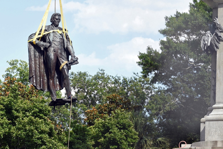 FILE - A statue of former U.S. Vice President and slavery advocate John C. Calhoun is raised by crews after its removal from a 100-foot-tall monument on Wednesday, June 24, 2020, in Charleston, S.C. Lawsuits filed to stop the removal of memorials to Confederate leaders and the pro-slavery congressman in a South Carolina city have been dropped. The Post and Courier reports that the American Heritage Association helped fund one of the lawsuits. It had been filed by descendants of John C. Calhoun, a former congressman and vice president who died before the Civil War.