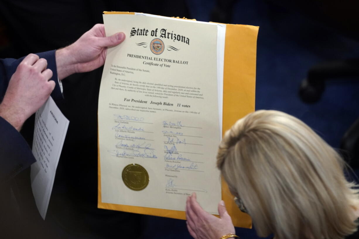 FILE - The certification of Electoral College votes for the state of Arizona is unsealed during a joint session of the House and Senate convenes to confirm the electoral votes cast in November's election, at the Capitol, Jan 6, 2021. Members of Congress have officially objected to the results in four of the last six presidential elections, a partisan practice that has been legal for over a century but became much more fraught after a violent mob of former President Donald Trump's supporters attacked the Capitol last year.