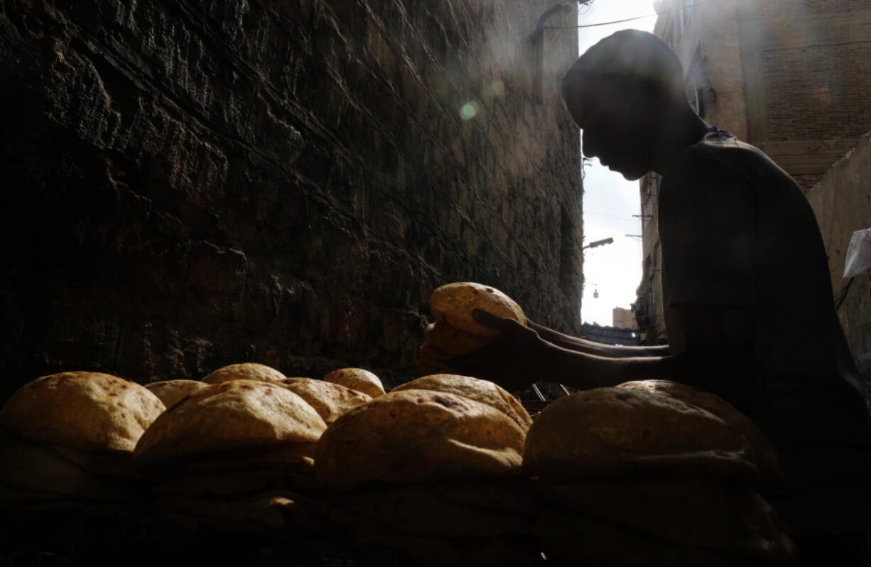 A baker stacks loaves of Egyptian traditional "baladi" flatbread outside a bakery, in the Old Cairo district of Cairo, Egypt, Sept. 8, 2022. For decades, millions of Egyptians have depended on the government to keep basic goods affordable. But a series of shocks to the global economy and Russia's invasion of Ukraine have endangered the social contract in the Middle East's most populous country, which is also the world's biggest importer of wheat. It is now grappling with double-digit inflation and a steep devaluation of its currency.