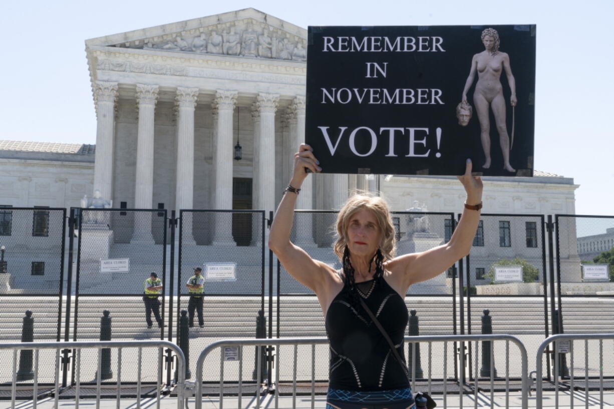 FILE - Nicky Sundt, of Washington, holds a sign with an image depicting Medusa that says, "Remember in November, Vote!," outside of the Supreme Court, June 29, 2022, in Washington. Democrats are pumping an unprecedented amount of money into advertising related to abortion rights, underscoring how central the message is to the party in the final weeks before the November midterm elections.