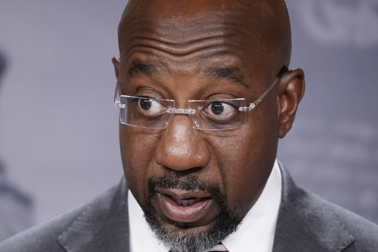 FILE - Sen. Raphael Warnock, D-Ga., speaks to reporters at the Capitol in Washington, July 26, 2022. Warnock of Georgia is urging the U.S. Treasury secretary to consider "maximum flexibility" for automakers and consumers in implementing a revised tax credit for Americans buying electric vehicles. The Democratic senator sent a letter to Treasury Secretary Janet Yellen on Friday, Sept. 23, raising concerns that changes to the tax credit President Joe Biden signed into law last month could place some automakers at a competitive disadvantage.   (AP Photo/J.