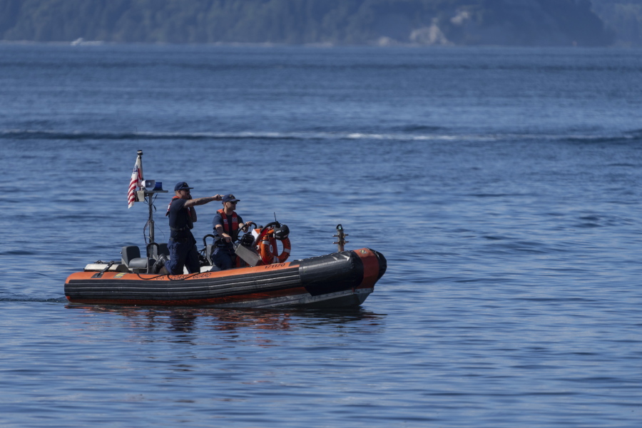 A U.S. Coast Guard boat searches the area, Monday, Sept. 5, 2022, near Freeland, Wash., on Whidbey Island north of Seattle where a chartered floatplane crashed the day before. The plane was carrying 10 people and was en route from Friday Harbor, Wash., to Renton, Wash.