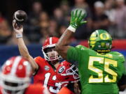 Georgia quarterback Stetson Bennett (13) throws under pressure from Oregon defensive lineman Taki Taimani (55) in the first half of an NCAA college football game game Saturday, Sept. 3, 2022, in Atlanta.