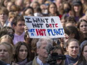 A sign reading "I want a hot date, not a hot planet" is held up in the crowd during a demonstration by climate activists in Berlin, Friday, Sept. 23, 2022. Youth activists staged a coordinated "global climate strike" on Friday to highlight their fears about the effects of global warming and demand more aid for poor countries hit by wild weather.