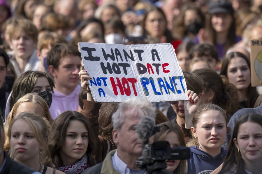 A sign reading "I want a hot date, not a hot planet" is held up in the crowd during a demonstration by climate activists in Berlin, Friday, Sept. 23, 2022. Youth activists staged a coordinated "global climate strike" on Friday to highlight their fears about the effects of global warming and demand more aid for poor countries hit by wild weather.