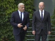 German Chancellor Olaf Scholz, right, and Israeli Prime Minister Yair Lapid, left, arrive for a joint press conference as part of a meeting at the chancellery in Berlin, Germany, Monday, Sept. 12, 2022.