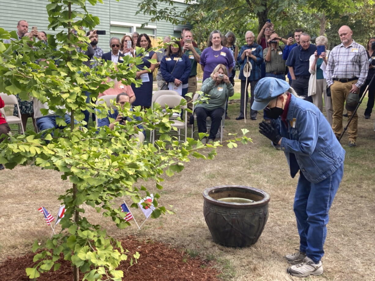 Hideko Tamura Snider, a survivor of the atomic bombing of Hiroshima, Japan, bows on Wednesday, Sept. 21, 2022, in Salem, Ore, before watering a ginkgo tree that came from a seed of a tree that also survived the bombing. Tamura Snider, who was 10-years-old when her city was destroyed by the atomic bomb and who now lives in Medford, Ore., was the guest of honor at a ceremony marking the culmination of a four-year-long campaign in Oregon to plant saplings grown from the seeds of trees that survived the atomic bombing of Hiroshima.
