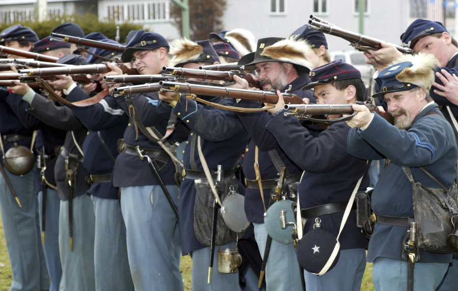 FILE -- Members of the Mifflin Guard, consisting of re-enactors from New York, New Jersey and Pennsylvania, rehearse some battlefield tactics, on March 28, 2004, on the grounds of the Kingston Armory in Wilkes-Barre Pa. Some historical battle re-enactors in New York are holding their musket fire because of worries over the state's new gun law that declares parks, government property and a long list of other places off limits to guns beginning in Sept. 2022.
