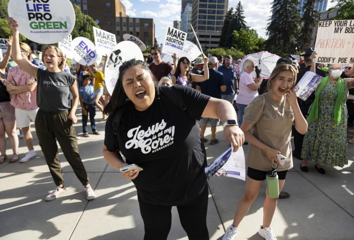FILE - Rebeca Castro, of Fruitland, sings and dances to a Christian praise song during an anti-abortion celebration for the overturn of Roe v. Wade, held outside of the Idaho Statehouse in Boise, Idaho on June 28, 2022. A University of Idaho memo warning staffers not to refer students to abortion or birth control providers has placed the school at the center of a debate over First Amendment rights and access to reproductive health care. One of the laws bars the use of state funds to promote or endorse abortion or emergency contraception. Another makes it illegal for non-healthcare providers to advertise abortions or birth control. (Sarah A.