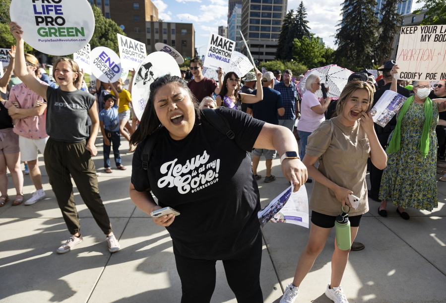 FILE - Rebeca Castro, of Fruitland, sings and dances to a Christian praise song during an anti-abortion celebration for the overturn of Roe v. Wade, held outside of the Idaho Statehouse in Boise, Idaho on June 28, 2022. A University of Idaho memo warning staffers not to refer students to abortion or birth control providers has placed the school at the center of a debate over First Amendment rights and access to reproductive health care. One of the laws bars the use of state funds to promote or endorse abortion or emergency contraception. Another makes it illegal for non-healthcare providers to advertise abortions or birth control. (Sarah A.