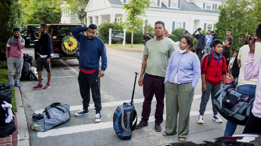 FILE - Migrants, who arrived on a flight sent by Florida Gov. Ron DeSantis, gather with their belongings outside St. Andrews Episcopal Church, Wednesday Sept. 14, 2022, in Edgartown, Mass., on Martha's Vineyard. A Texas sheriff on Monday, Sept. 19 opened an investigation into two flights of migrants sent to Martha's Vineyard by DeSantis, but did not say what laws may have been broken in putting 48 Venezuelans on private planes last week from San Antonio.