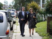 Dan Sideris and his wife, Carrie Sideris, of Newton, Mass., walk along a sidewalk Sept. 1 as they return to door-to-door visits as Jehovah's Witnesses in Boston.
