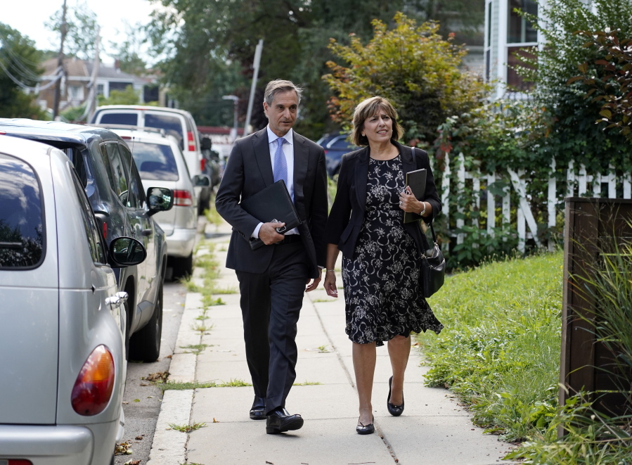 Dan Sideris and his wife, Carrie Sideris, of Newton, Mass., walk along a sidewalk Sept. 1 as they return to door-to-door visits as Jehovah's Witnesses in Boston.