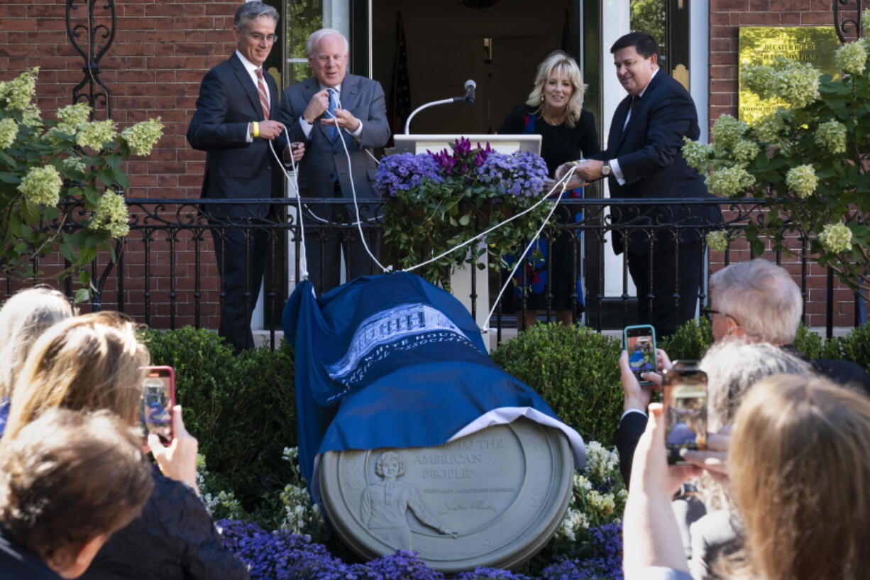 Artist Chas Fagan, left, John Rogers, chair of the White House Historical Association (WHAA) Board of Directors, first lady Jill Biden, and Stuart McLaurin, President of the WHHA, unveil a medallion sculpture honoring former first lady Jacqueline Kennedy at the Decatur House, Friday, Sept. 23, 2022, near the White House in Washington.