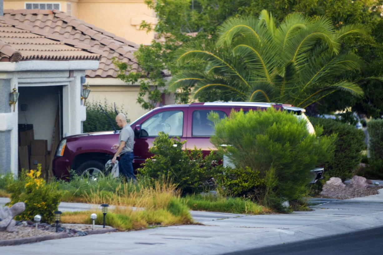 A police officer stands near the front door of the house of Clark County Public Administrator Robert Telles, Wednesday, Sept. 7, 2022, in Las Vegas. Authorities served search warrants at Telles home earlier in the day in connection with the fatal stabbing of Las Vegas Review-Journal investigative reporter Jeff German.
