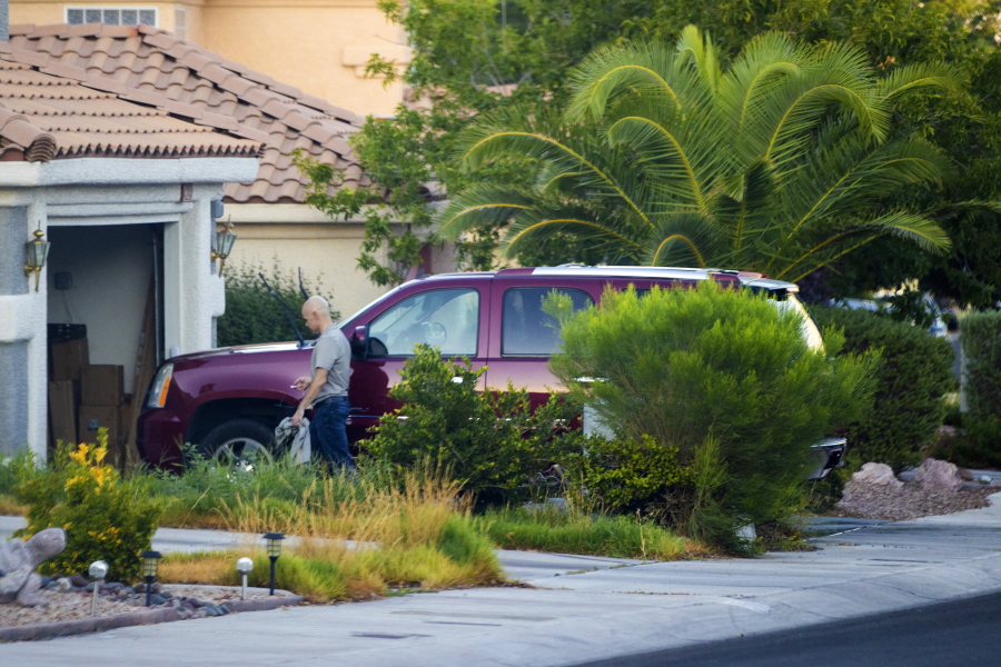A police officer stands near the front door of the house of Clark County Public Administrator Robert Telles, Wednesday, Sept. 7, 2022, in Las Vegas. Authorities served search warrants at Telles home earlier in the day in connection with the fatal stabbing of Las Vegas Review-Journal investigative reporter Jeff German.
