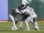 Seattle Mariners' Sam Haggerty, from left, celebrates with Jarred Kelenic and Mitch Haniger after the Mariners defeated the Oakland Athletics in a baseball game in Oakland, Calif., Thursday, Sept. 22, 2022.