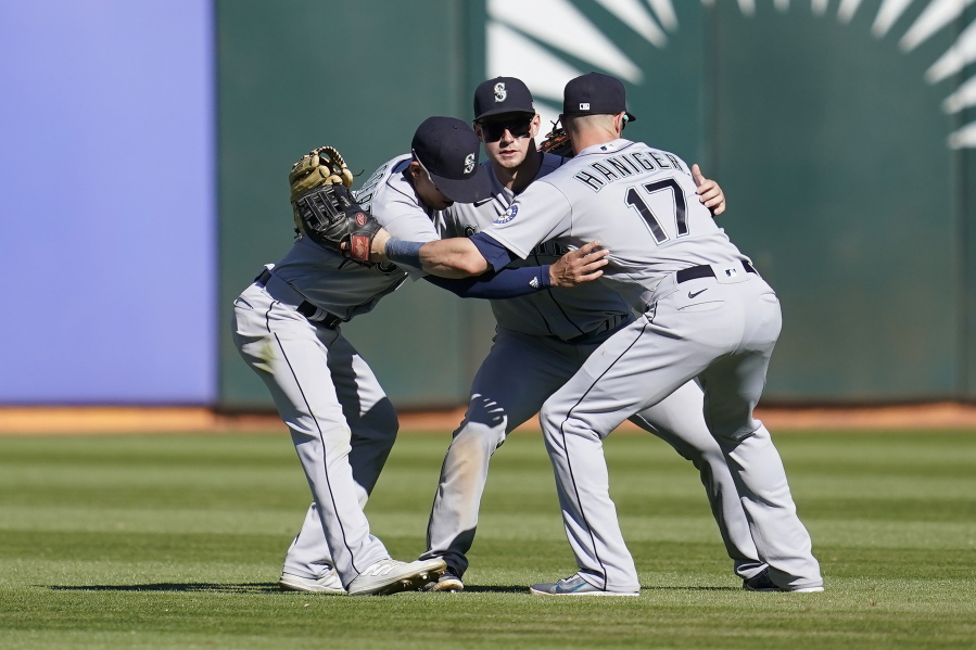 Seattle Mariners' Sam Haggerty, from left, celebrates with Jarred Kelenic and Mitch Haniger after the Mariners defeated the Oakland Athletics in a baseball game in Oakland, Calif., Thursday, Sept. 22, 2022.