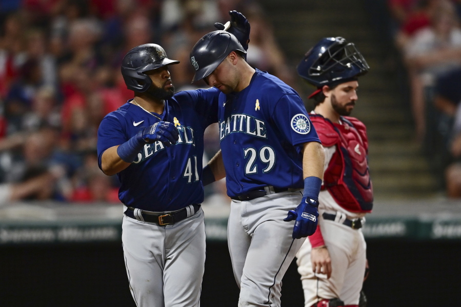 Seattle Mariners' Cal Raleigh, front right, is congratulated by Carlos Santana after hitting three-run home run off Cleveland Guardians relief pitcher Bryan Shaw during the sixth inning of a baseball game Friday, Sept. 2, 2022, in Cleveland.