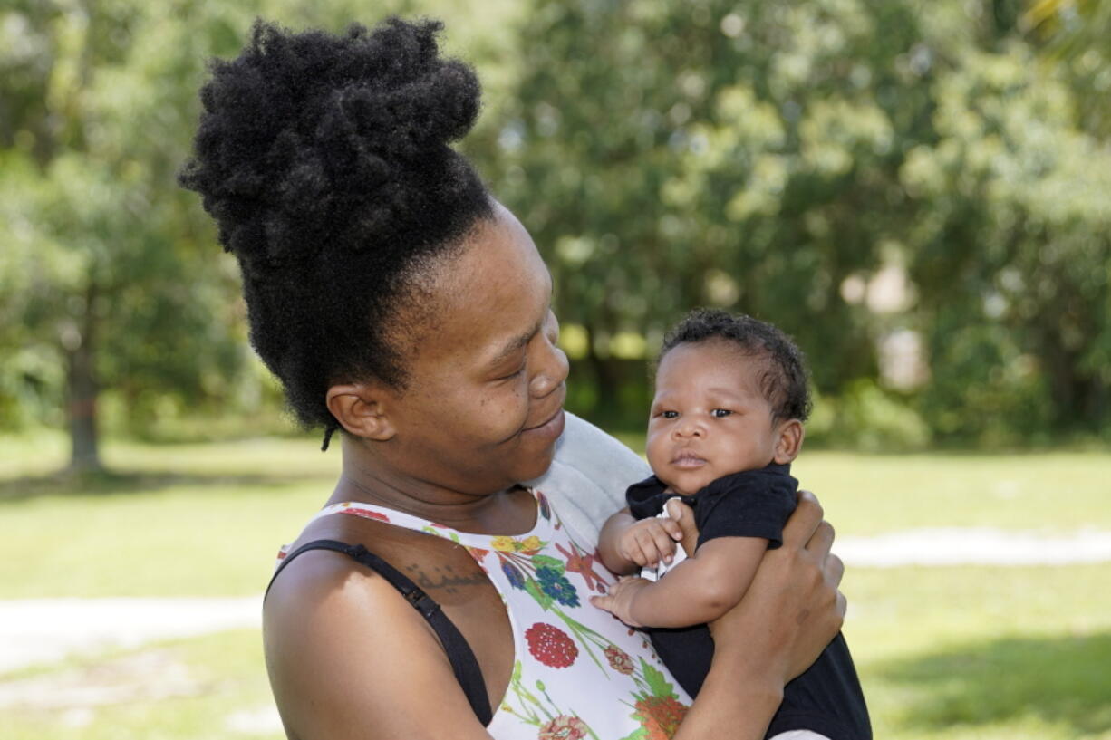 Venessa Aiken holds her son Jahzir Robinson, five weeks old, outside their home Sunday, Aug. 21, 2022, in Orlando, Fla.