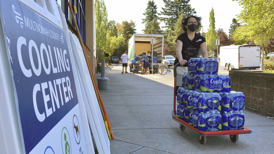 FILE - A volunteer unloads bottled water at a cooling center established to help vulnerable residents ride out a dangerous heat wave on Aug. 11, 2021. Oregon is set to become the first state in the nation to cover certain climate change expenses under its Medicaid program.