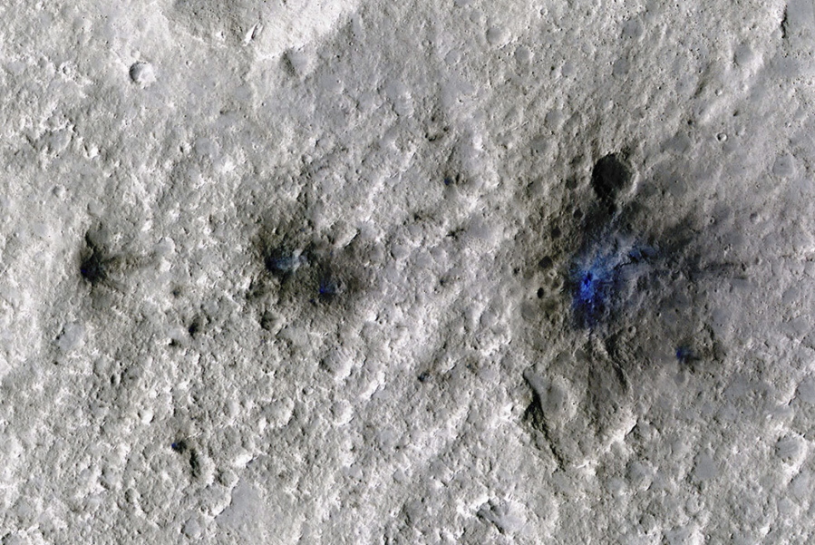This undated photo released by NASA shows craters that were formed by a Sept. 5, 2021, meteoroid impact on Mars, the first to be detected by NASA's InSight. Taken by NASA's Mars Reconnaissance Orbiter, this enhanced-color image highlights the dust and soil disturbed by the impact in blue in order to make details more visible to the human eye. NASA lander on Mars has captured the vibrations and sounds of four meteorites striking the planet's surface. Scientists reported Monday, Sept. 19, 2022, that Mars InSight detected seismic and acoustic waves from a series of impacts in 2020 and 2021.