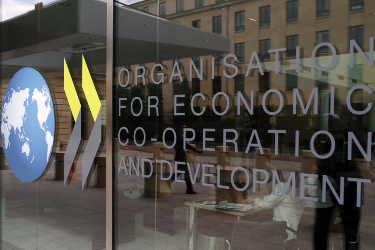 FILE - The logo at the entrance of the Organisation for Economic Co-operation and Development (OECD) headquarters in Paris, June 7, 2017. The OECD on Monday, Sept. 26, 2022 says Russia's war in Ukraine and the lingering effects of the COVID-19 pandemic are dragging down global economic growth more than expected and driving up inflation that will stay high into next year. The Paris-based organization projects worldwide growth to be a modest 3% this year before slowing further to just 2.2% next year, representing around $2.8 trillion in lost global output in 2023.