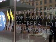 FILE - The logo at the entrance of the Organisation for Economic Co-operation and Development (OECD) headquarters in Paris, June 7, 2017. The OECD on Monday, Sept. 26, 2022 says Russia's war in Ukraine and the lingering effects of the COVID-19 pandemic are dragging down global economic growth more than expected and driving up inflation that will stay high into next year. The Paris-based organization projects worldwide growth to be a modest 3% this year before slowing further to just 2.2% next year, representing around $2.8 trillion in lost global output in 2023.