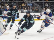 Seattle Kraken forward Matty Beniers, center, skates against Edmonton Oilers forward Luke Esposito during the second period of a preseason NHL hockey game, Monday, Sept. 26, 2022, in Seattle.